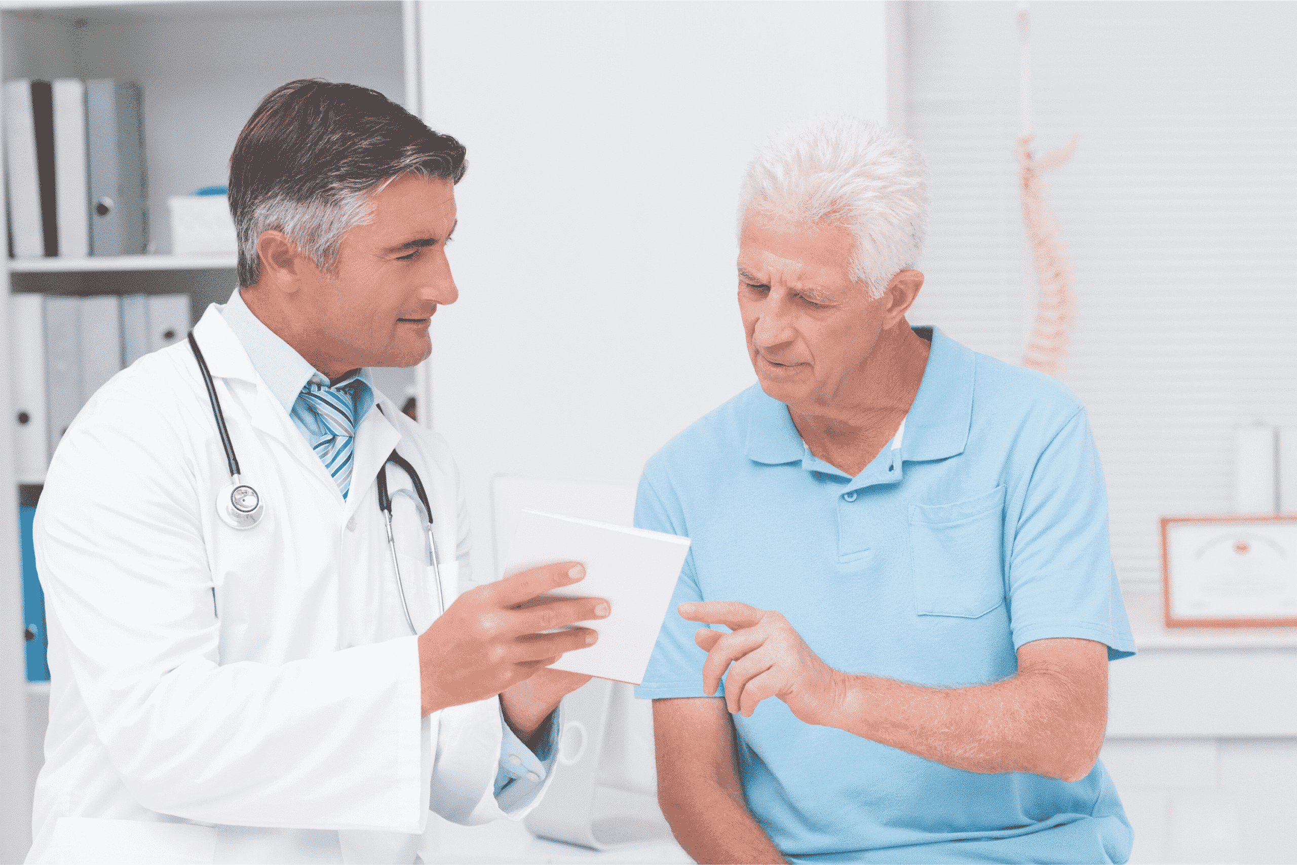 A doctor in a white shirt holding a notepad, explaining recovery details to a patient after a car accident in a Brooklyn clinic.
